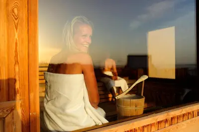 a woman sitting on a balcony looking in a window at The Breakers Diving and Surfing Lodge Soma Bay in Hurghada