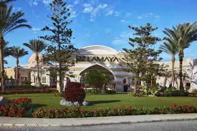 a building in a park with trees and flowers at JAZ Lamaya Resort in Coraya Bay