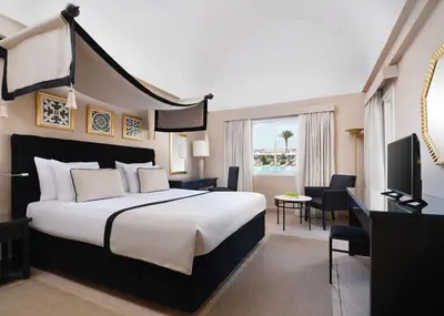 a hotel room with a large bed and a desk at JAZ Makadina in Hurghada