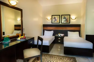 a hotel room with two beds and a desk at Obelisk Nile Hotel Aswan in Aswan