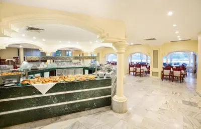 a breakfast buffet in a large room with tables and chairs at Obelisk Nile Hotel Aswan in Aswan