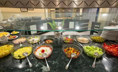 a buffet with many bowls of food and spoons at Obelisk Nile Hotel Aswan in Aswan