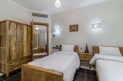 a bedroom with two beds and a mirror at Royal Beach Serviced Apartments in Hurghada