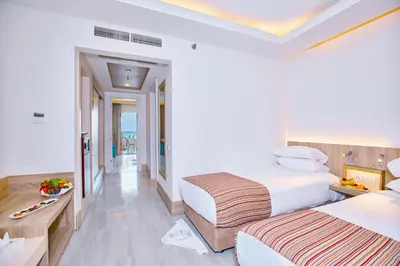 a hotel room with two beds and a balcony at Titanic Beach - Families and Couples only in Hurghada