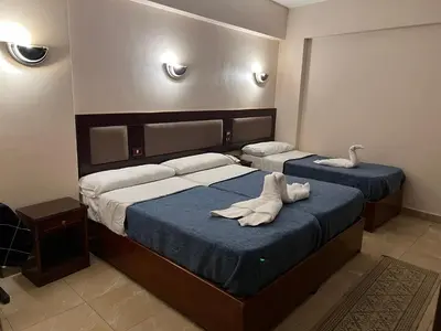 two beds in a bedroom with towels on them at Anglo Hotel in Luxor
