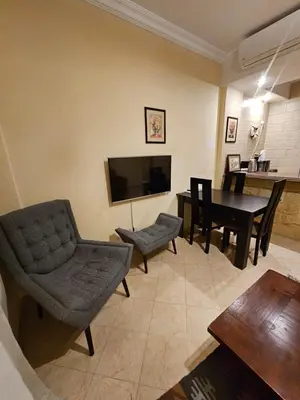 a living room with a television and a table and chairs at Palm Beach Apartments 302B in Hurghada