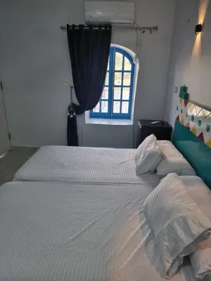 a bedroom with a large white bed with a window at Baba Dool in Aswan