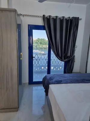 a bedroom with a bed and a door with a window at Baba Dool in Aswan
