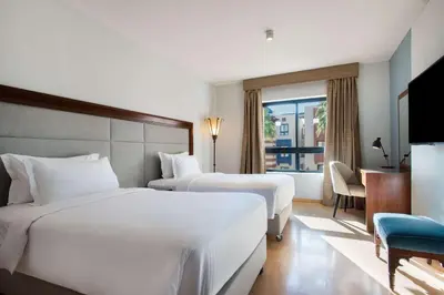 a hotel room with two beds and a television at Marina Resort Port Ghalib, a member of Radisson Individuals in Port Ghalib