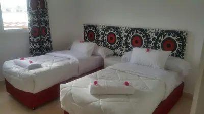 a bedroom with two beds with white sheets and red accents at Twin Lagoon Apartment at White Villas El Gouna in Hurghada