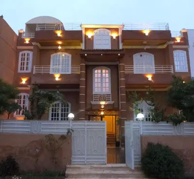 a large house with a white fence in front of it at Luxor Star Apartments in Luxor