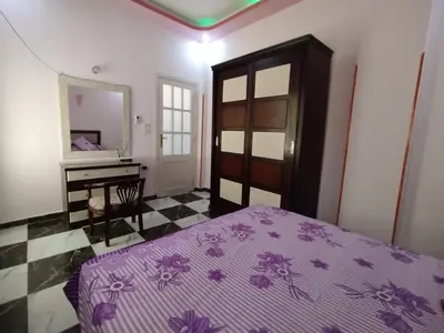 a bedroom with a purple bed and a mirror at Luxor Star Apartments in Luxor