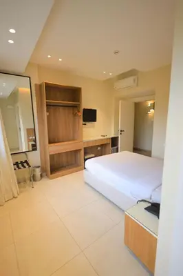a bedroom with a large white bed and a desk at Hapi Hotel in Aswan