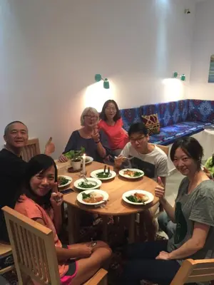 a group of people sitting around a table eating food at The Mango Guest House in Aswan
