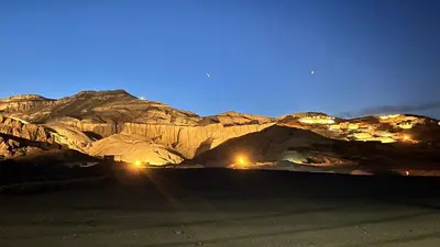 a view of a mountain at night with lights at Luxor palace Apartments in Luxor