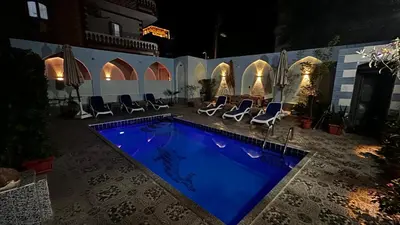 a swimming pool in a courtyard with chairs around it at Luxor palace Apartments in Luxor
