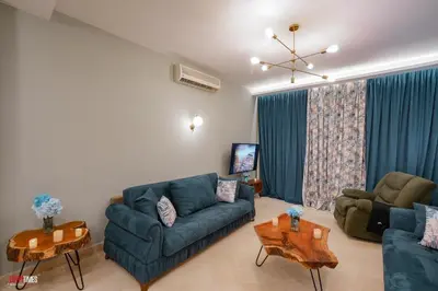 a living room with a blue couch and a table at El Gouna South Marina 1 Bedroom Apartement with private Jacuzzi in Hurghada