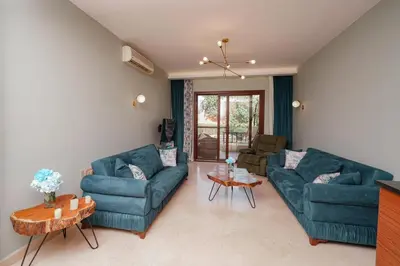 a living room with two blue couches and a table at El Gouna South Marina 1 Bedroom Apartement with private Jacuzzi in Hurghada