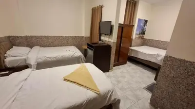 a hotel room with two beds and a television at Canary Hotel in Hurghada