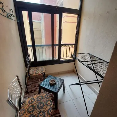 a balcony with a table and a chair and a window at Esplanada Beach Apartment, no single men in Hurghada