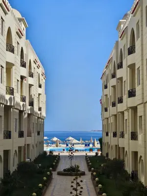 a view of two buildings with the ocean in the background at Palm Beach Piazza Apart hotel Sahl Hasheesh in Hurghada