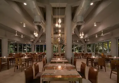 a dining room with tables and chairs and windows at Sindbad Club in Hurghada
