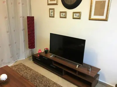 a living room with a flat screen tv on a entertainment center at Pool View Apartments at British Resort - Unit 13 in Hurghada