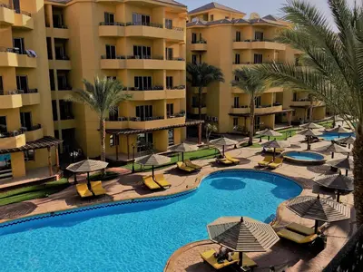 an aerial view of a resort swimming pool with umbrellas at Pool View Apartments at British Resort - Unit 13 in Hurghada