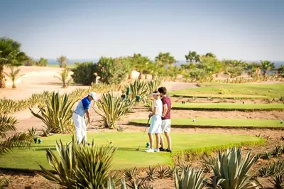 a group of people playing golf on a golf course at Robinson Soma Bay in Hurghada