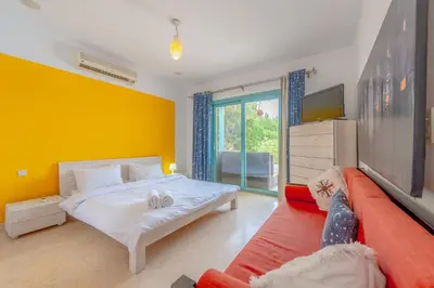 a bedroom with a bed and a couch and a tv at Stunning Villa for Rent in El Gouna HEATED PRIVATE POOL in Hurghada