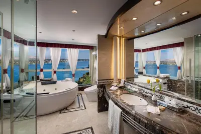 a bathroom with two sinks and a tub and a large mirror at Sonesta St. George Hotel - Convention Center in Luxor