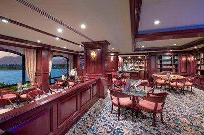 a restaurant with a bar and tables and chairs at Sonesta St. George Hotel - Convention Center in Luxor