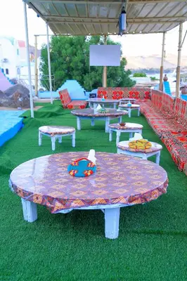 a group of tables and benches in a park at Nubian Palace Eco Lodge - A Nubian Home Since 1959 in Aswan