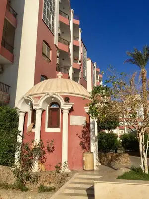 a red and white building with a dome on it at Desert Pearl Apartment in Hurghada