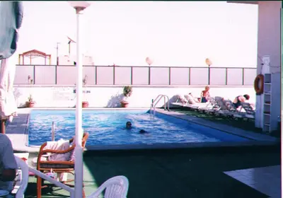 a swimming pool with people in the water at St.Joseph Hotel in Luxor