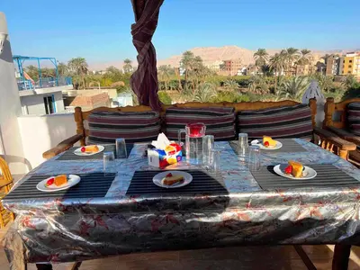 a table with plates of food on top of a balcony at Gold Ibis Hotel in Luxor