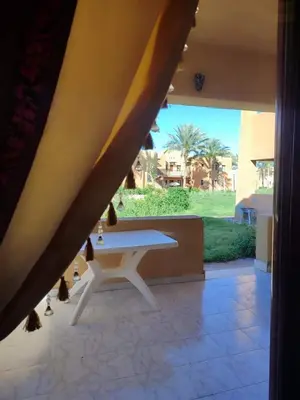 a white table in a room with a view of a yard at chalet Stella de Mari in Makadi Bey in Hurghada