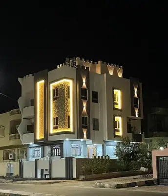 a large building with lights on it at night at Villamar Sea View rooms & apartments in Hurghada