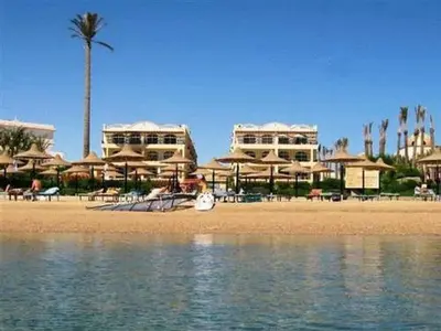 a beach with chairs and umbrellas on the beach at Apartment at Palm Beach Piazza in Hurghada