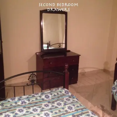 a bedroom with a bed and a dresser with a mirror at Apartment at Palm Beach Piazza in Hurghada