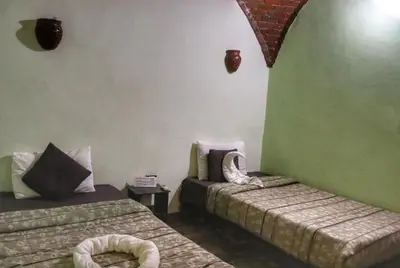 a room with two beds and a green wall at Hadouta Masreya Nubian Guest House in Aswan