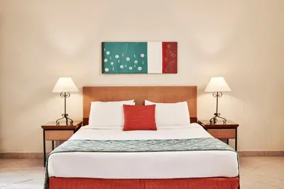 a bedroom with a large bed with two lamps at Fanadir Hotel El Gouna in Hurghada