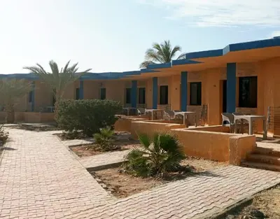 a building with tables and chairs in front of it at Mangrove Bay Resort in Quseir