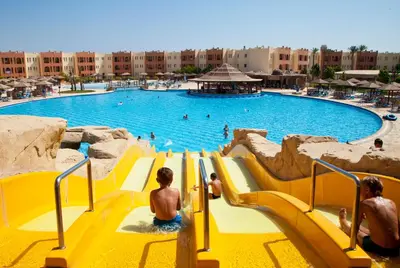 a yellow slide in a pool with people in it at Sunrise Royal Makadi Resort in Hurghada