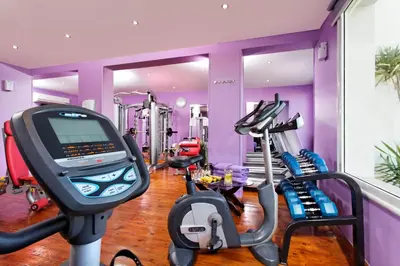 a gym with purple walls and two tread machines at Pickalbatros Dana Beach Resort - Aqua Park in Hurghada