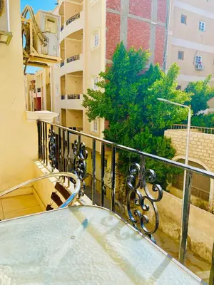 a balcony of a building with a glass table at Panda Grey with balcony Hurghada center in Hurghada