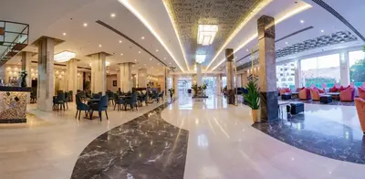 a lobby with tables and chairs in a building at Sphinx Aqua Park Beach Resort in Hurghada