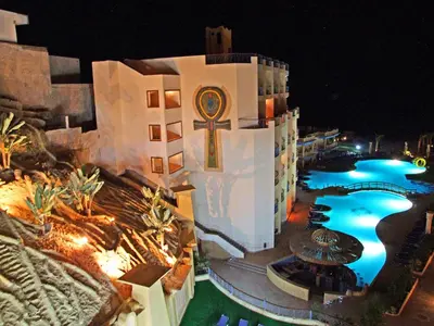 a building with a swimming pool at night at Sphinx Aqua Park Beach Resort in Hurghada