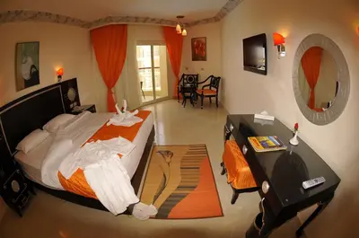 a bedroom with a bed and a desk and a mirror at Sphinx Aqua Park Beach Resort in Hurghada