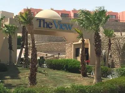 a building with palm trees in front of it at Sea View Duplex Villa in Hurghada